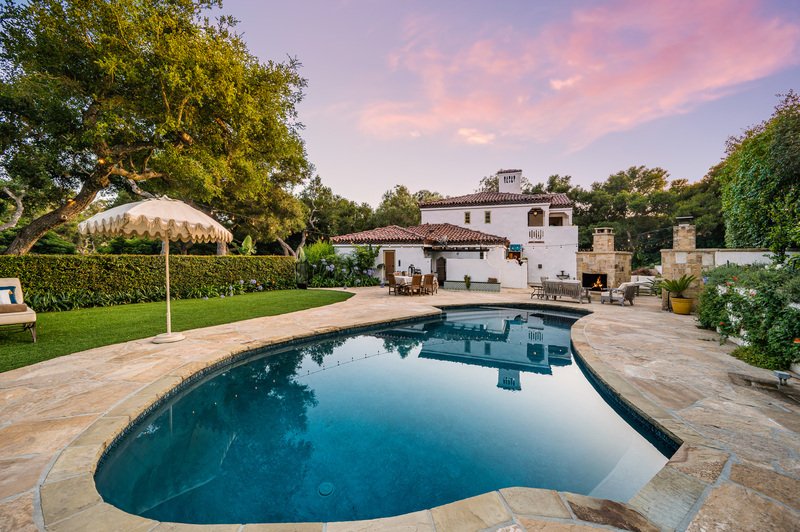 Casa grande con alberca y jardín al atardecer